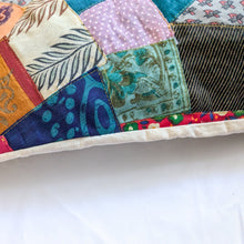 Load image into Gallery viewer, Close up view of sari patchwork cushion cover on a pillow, laying on white surface