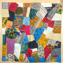 Load image into Gallery viewer, Sari patchwork cushion cover lying flat on a wooden table