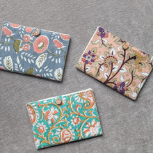 Load image into Gallery viewer, Three floral-patterned fabric passport covers on a gray surface