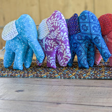 Load image into Gallery viewer, Fabric elephants of different colours arranged on a patterned mat.
