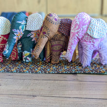 Load image into Gallery viewer, Colorful fabric elephants on a wooden surface with a patterned mat underneath.
