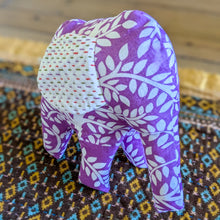 Load image into Gallery viewer, Purple fabric elephant with white patterns on a colorful patterned surface
