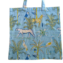 Load image into Gallery viewer, Tote bag with animal and plant pattern on a blue background
