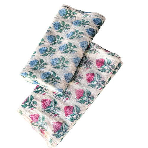 Two floral-patterned scarves stacked on a white surface