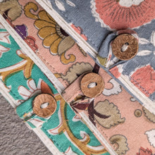 Load image into Gallery viewer, Close-up of patterned fabric with coconut shell buttons on a textured surface
