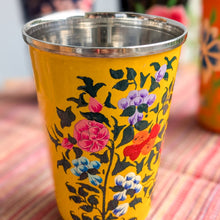 Load image into Gallery viewer, Yellow cup with floral design on a patterned surface
