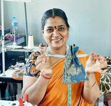 Load image into Gallery viewer, smiling artisan holding sari gift bag
