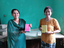 Load image into Gallery viewer, Lokta paper notebooks held by smiling artisans
